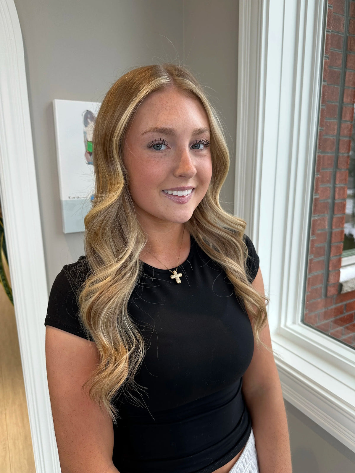 Face framing blonde highlights on a smiling client