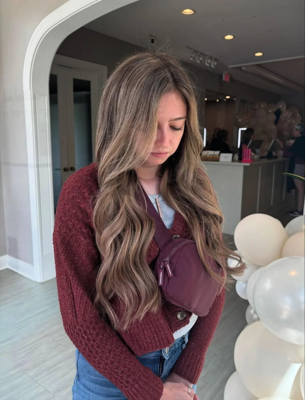 Long wavy hair extensions with blonde and light brown dimension, front view