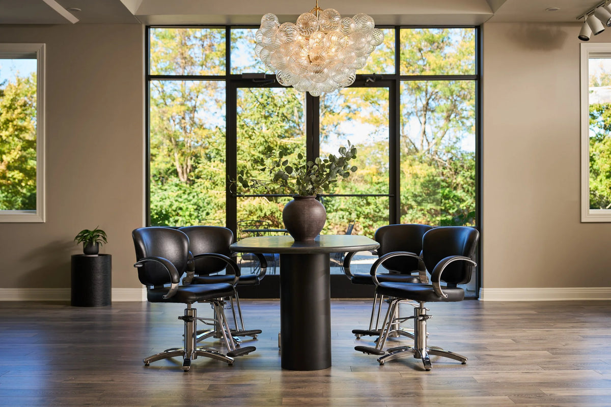 The salon floor with styling chairs and tall windows